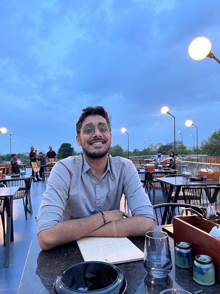 Brijesh smiling at an outdoor table